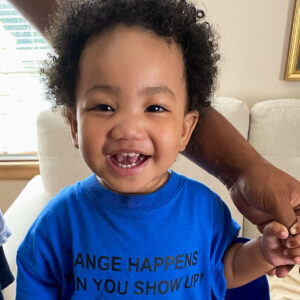 A young child smiles.