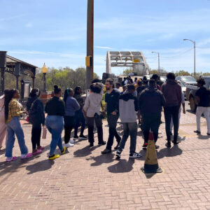 A crowd walks toward a bridge.